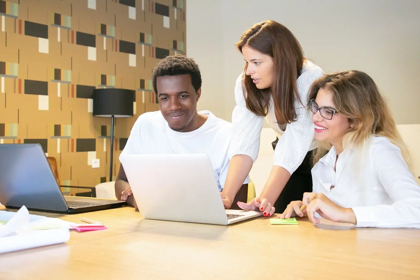 Fröhliche Bürokollegen sehen sich gemeinsam eine Projektpräsentation an.